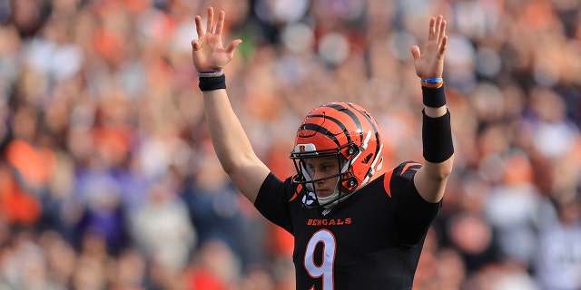 Cincinnati Bengals quarterback Joe Burrow (9) reacts after a touchdown run by Joe Mixon during the first half of an NFL football game against the Baltimore Ravens, Sunday, Dec. 26, 2021, in Cincinnati.