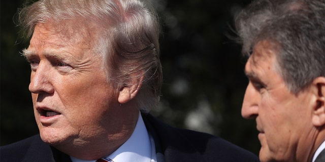 President Trump talks with Sen. Joe Manchin, D-W.Va., during an event to honor the 2017 NCAA Football National Champion Alabama Crimson Tide at the White House, on April 10, 2018, in Washington.