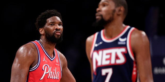 Philadelphia 76ers center Joel Embiid (21) looks toward Brooklyn Nets forward Kevin Durant (7) during the second half of an NBA basketball game Thursday, Dec. 30, 2021, in New York. 76ers won 110-102.