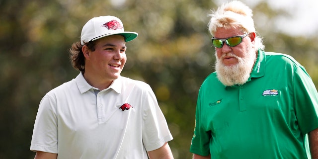 John Daly II, left walks off the fourth green with father John Daly during the second round of the PNC Championship golf tournament Sunday, Dec. 19, 2021, in Orlando, Fla.