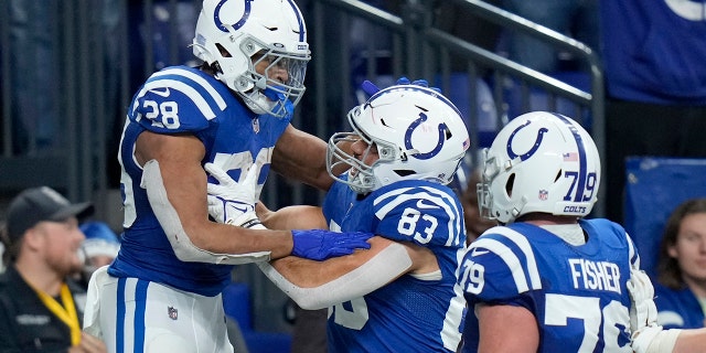 Indianapolis Colts running back Jonathan Taylor (28) is congratulated by Kylen Granson (83) and Eric Fisher (79) after scoring on a 67-yard touchdown run during the second half of an NFL football game against the New England Patriots Saturday, Dec. 18, 2021, in Indianapolis.