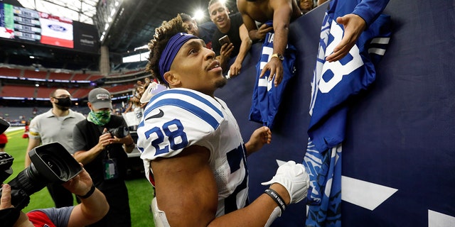 Indianapolis Colts running back Jonathan Taylor (28) signs autographs for fans after an NFL football game against the Houston Texans, Sunday, Dec. 5, 2021, in Houston. 