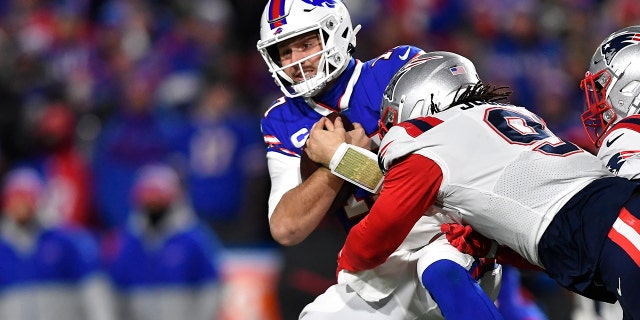 O quarterback do Buffalo Bills, Josh Allen (17), é enfrentado pelo New England Patriots fora do linebacker Matt Godon (9) durante a primeira metade de um jogo de futebol americano da NFL em Orchard Park, Nova York, segunda-feira, 6 de dezembro de 2021.