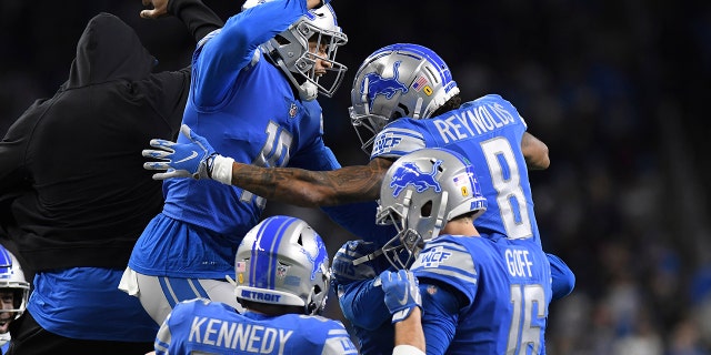 Teammates congratulate Detroit Lions wide receiver Josh Reynolds (8) after his touchdown during the first half of an NFL football game against the Arizona Cardinals, Sunday, Dec. 19, 2021, in Detroit.