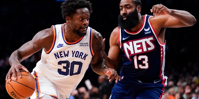 New York Knicks forward Julius Randle (30) drives against Brooklyn Nets guard James Harden (13) during Tuesday, Nov. 30, 2021, in New York.