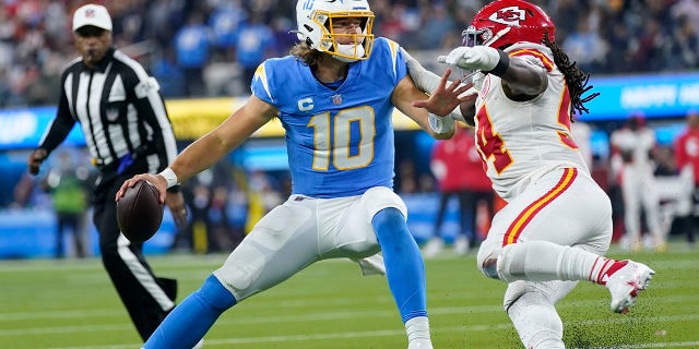 Los Angeles Chargers quarterback Justin Herbert, left, appears to come under pressure from Kansas City Chiefs outside linebacker Nick Bolton in the second half of an NFL football game on Thursday 16 December 2021 in Inglewood, California.