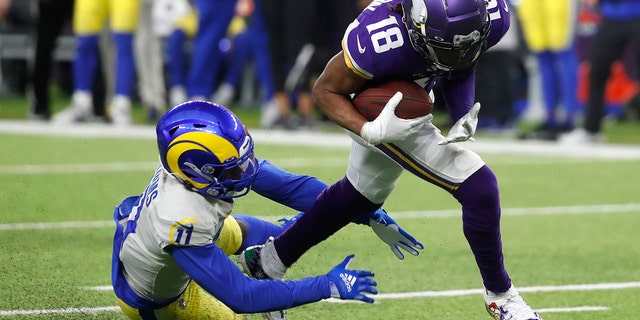 Minnesota Vikings wide receiver Justin Jefferson (18) runs from Los Angeles Rams cornerback Darious Williams (11) after catching a pass during the second half of an NFL football game, Sunday, Dec. 26, 2021, in Minneapolis.