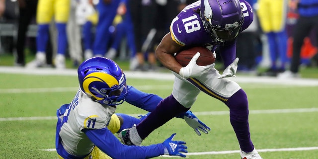 Minnesota Vikings wide receiver Justin Jefferson (18) runs from Los Angeles Rams cornerback Darious Williams (11) after catching a pass during the second half of an NFL football game, Sunday, Dec. 26, 2021, in Minneapolis.