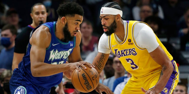 Minnesota Timberwolves center Karl-Anthony Towns (32) beats Los Angeles Lakers forward Anthony Davis (3) in the first quarter of an NBA basketball game on Friday, December 17, 2021, in Minneapolis.