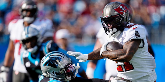 Tampa Bay Buccaneers running back Ke'Shawn Vaughn runs for a touchdown past Carolina Panthers free safety Juston Burris during the first half Sunday, Dec. 26, 2021, in Charlotte, N.C.