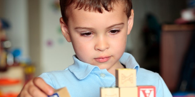Child deciding where is the best place to put his block. 