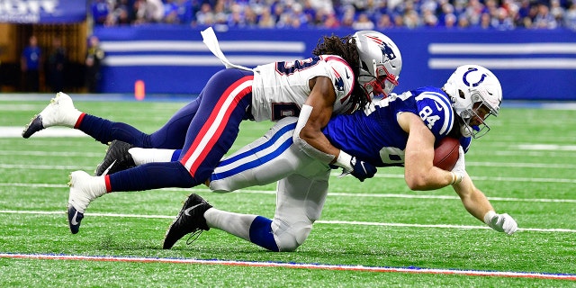 New England Patriots safety Kyle Dugger (23) tackles Indianapolis Colts tight end Jack Doyle (84) during the second half at Lucas Oil Stadium. The Colts won 27-17.