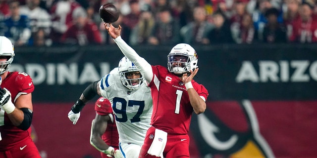 Arizona Cardinals quarterback Kyler Murray (1) throws as Indianapolis Colts defensive end Al-Quadin Muhammad (97) pursues during the second half Dec. 25, 2021, in Glendale, Ariz.