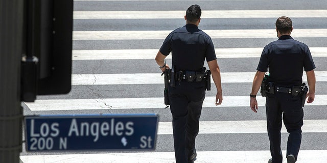 LAPD members make their way down Temple Street in downtown Los Angeles.