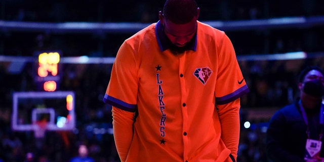 El delantero de los Lakers de Los Ángeles LeBron James (6) Mira hacia abajo mientras suena el himno nacional antes de un partido de baloncesto de la NBA contra Los Angeles Clippers en Los Ángeles., viernes, dic. 3, 2021.