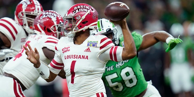 Louisiana-Lafayette quarterback Levi Lewis (1) passes under pressure from Marshall defensive lineman Elijah Alston (58) in the first half of the New Orleans Bowl NCAA football game in New Orleans, Saturday, Dec. 18, 2021.