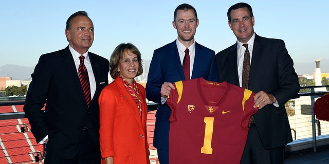 New USC football head coach Lincoln Riley (C) posses with USC Board of Trustees Chair Rick Caruso (L) university president Carol L. Folt and athletic director Mike Bohn (R) during a news conference in the 1923 Club at the Los Angeles Coliseum on November 29, 2021 in Los Angeles, California.