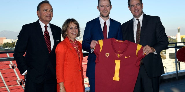 New USC football coach Lincoln Riley (center) posses with USC Board of Trustees Chair Rick Caruso (left) university president Carol L. Folt and athletic director Mike Bohn (right) during a news conference in the 1923 Club at the Los Angeles Coliseum Nov. 29, 2021.