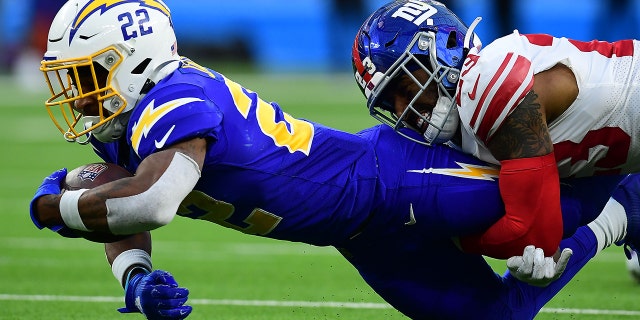 Los Angeles Chargers running back Justin Jackson is brought down by New York Giants safety Logan Ryan at SoFi Stadium on Dec. 12, 2021, in Inglewood, California.