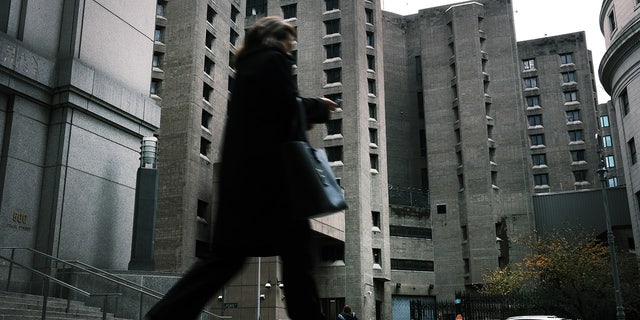 A woman walks by the Metropolitan Correctional Center, which is operated by the Federal Bureau of Prisons. 