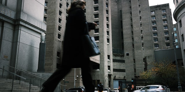 A woman walks by the Metropolitan Correctional Center, which is operated by the Federal Bureau of Prisons.