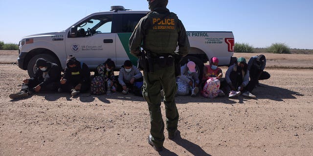 A group of asylum seekers from Mexico, Cuba and Haiti is detained by U.S. Border Patrol in San Luis, Ariz., April 19, 2021.