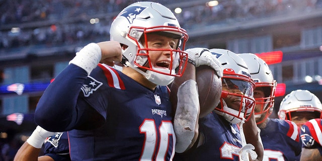 New England Patriots running back Damien Harris, right, celebrates with quarterback Mac Jones, left, after his touchdown during the second half of an NFL football game against the Tennessee Titans, Sunday, Nov. 28, 2021, in Foxborough, Massachusetts.