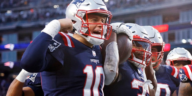 New England Patriots running back Damien Harris, right, celebrates with quarterback Mac Jones, left, after his touchdown during the second half of an NFL football game against the Tennessee Titans, Sunday, Nov. 28, 2021, in Foxborough, Massachusetts.