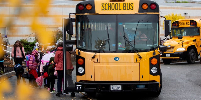 Students board buses at East End Community School at the end of a school day in Portland, Maine.