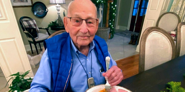 World War II veteran Major Wooten enjoys his Thanksgiving dinner with family in Madison, Alabama, on Nov. 25, 2021. (Holly McDonald via AP)