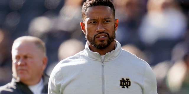 Notre Dame defensive coordinator Marcus Freeman watches during warmups before an NCAA college football game against Navy in South Bend, Indiana, Sabato, Nov. 6, 2021.