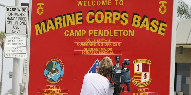 FILE: A TV cameraman tapes footage of the sign at the entrance to Camp Pendleton Marine Corps Base in California 21 June, 2006. (Photo credit should read ROBYN BECK/AFP via Getty Images)