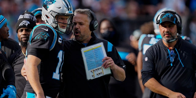 Carolina Panthers head coach Matt Rhule talks with quarterback Sam Darnold during the first half of an NFL football game against the Tampa Bay Buccaneers Sunday, Dec. 26, 2021, in Charlotte, N.C.