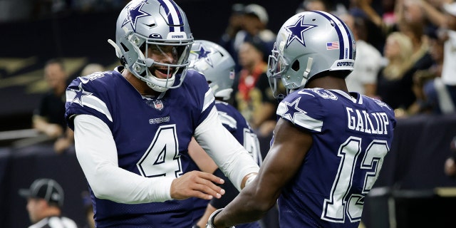 O quarterback do Dallas Cowboys Dak Prescott (4) comemora o touchdown do Dallas Cowboys, Michael Gallup (13), durante a primeira metade de um jogo de futebol americano da NFL contra o New Orleans Saints, quinta-feira, 2 de dezembro de 2021, em New Orleans.