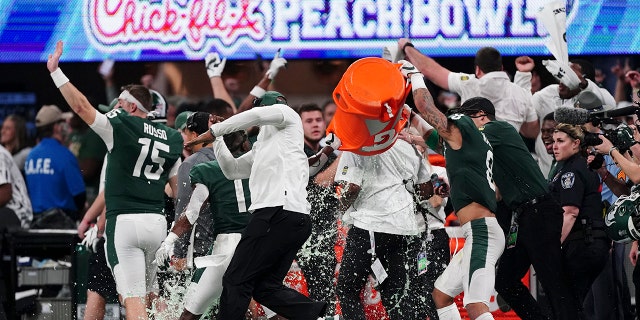 The Michigan State team celebrates a victory over Pittsburgh after the Peach Bowl NCAA college football game, Thursday, Dec. 30, 2021, in Atlanta. Michigan State won 31-21.