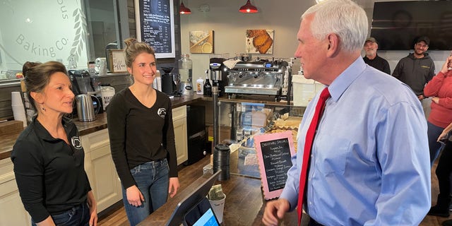 Former Vice President Mike Pence speaks with the owners of Simply Delicious Baking Company, il dic. 8, 2021 in Bedford, New Hampshire.