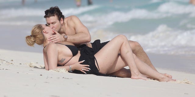 Shanna Moakler e namorado se beijam na praia no México