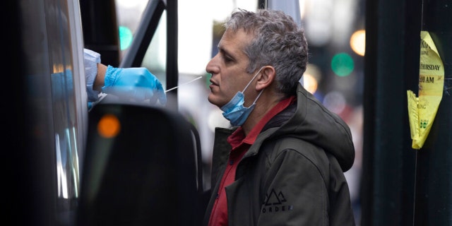 A person takes COVID-19 test at mobile testing site near Grand Central Terminal on Friday, Dec. 3, 2021, in New York. The omicron variant of COVID-19, which had been undetected in the U.S. before the middle of this week, had been discovered in at least five states by the end of Thursday, showing yet again how mutations of the virus can circumnavigate the globe with speed and ease. (AP Photo/Yuki Iwamura)