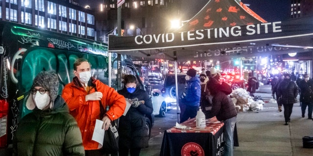 Люди ждут в очереди, чтобы пройти тестирование на COVID в Нижнем Ист-Сайде во вторник, 21 декабря 2021 года, в Нью-Йорке. (Фото AP/Бриттани Ньюман)