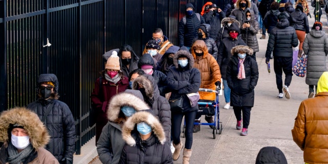 People line up to receive test kits to detect COVID-19 as they are distributed in the Lower East Side neighborhood in the Manhattan borough of New York Thursday, Dec. 23, 2021.