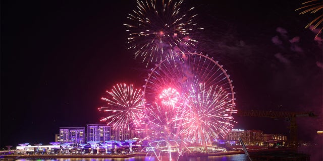 A picture taken on December 31, 2021 shows fireworks erupting in front of Ain Dubai.