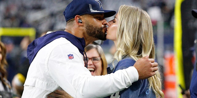 Dak Prescott #4 of the Dallas Cowboys kisses his girlfriend Natalie Buffett before the game against the Washington Football Team at AT&amp;T Stadium on December 26, 2021 in Arlington, Texas.