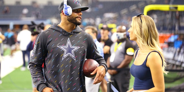 Dak Prescott # 4 of the Dallas Cowboys talks to Natalie Buffett on the pitch before their game against the Carolina Panthers at AT&T Stadium on October 03, 2021 in Arlington, Texas.