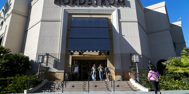 A security guard patrols the front entrance of the Nordstrom store at The Grove shopping center in Los Angeles on Nov. 23 after an organized group of thieves attempted a smash-and-grab robbery.