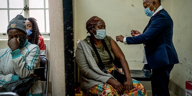 A woman is vaccinated against COVID-19 at the Hillbrow Clinic in Johannesburg, South Africa, Monday Dec. 6, 2021. South African doctors say the rapid increase in COVID-19 cases attributed to the new omicron variant is resulting in mostly mild symptoms. 