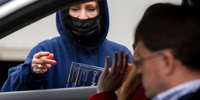 Youngstown City Heath Department worker Kathy Johnson talks with drivers before giving them at-home COVID-19 test kits during a distribution event, Thursday, Dec. 30, 2021, in Youngstown, Ohio. 