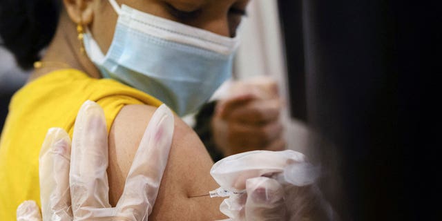A girl receives the Pfizer-BioNTech coronavirus vaccine in Lansdale, Wel., op Des. 5, 2021.