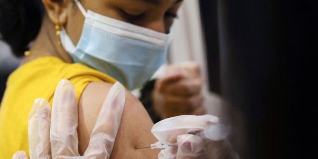 A girl receives the Pfizer-BioNTech coronavirus vaccine in Lansdale, Pa., on Dec. 5, 2021.