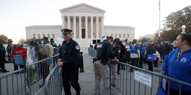 Supreme Court police officers erect a barrier between protesters outside the court building, ahead of arguments in the Mississippi abortion rights case Dec. 1, 2021.