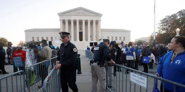 Supreme Court Police officers erect a barrier between anti-abortion and pro-abortion rights protesters outside the court building, ahead of arguments in the Mississippi abortion rights case Dobbs v. Jackson Women's Health, in Washington, Dec. 1, 2021.